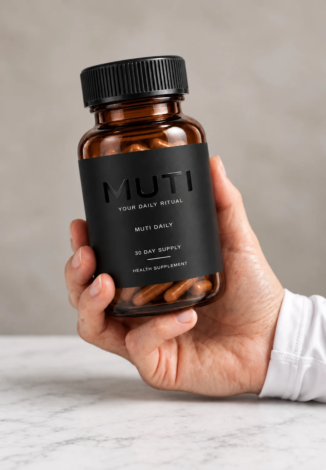 A hand holding the MUTI DAILY bottle above a breakfast table in morning light